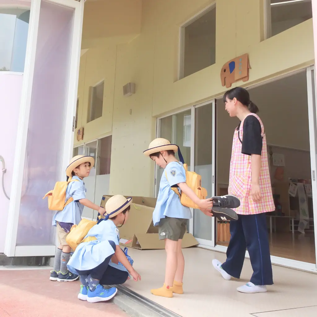 先生の案内で園内を見学する親子の様子